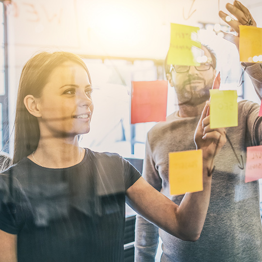 two people looking at sticky notes